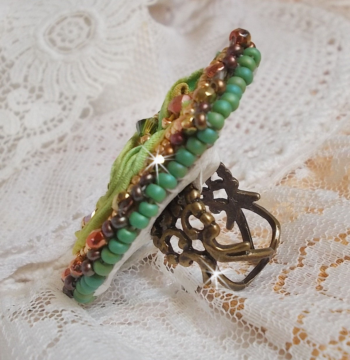 Bague Lune V&eacute;nitienne brod&eacute;e avec un ruban de soie Orange, Vert et Jaune, cristaux : toupies, perles rondes nacr&eacute;es et chatons. S&rsquo;ajoute des facettes et rocailles en Verre sur une bague filigran&eacute;e 