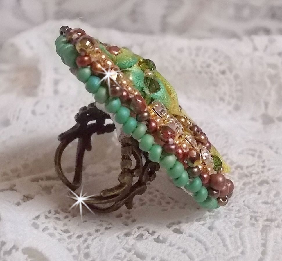 Bague Lune V&eacute;nitienne brod&eacute;e avec un ruban de soie Orange, Vert et Jaune, cristaux : toupies, perles rondes nacr&eacute;es et chatons. S&rsquo;ajoute des facettes et rocailles en Verre sur une bague filigran&eacute;e 