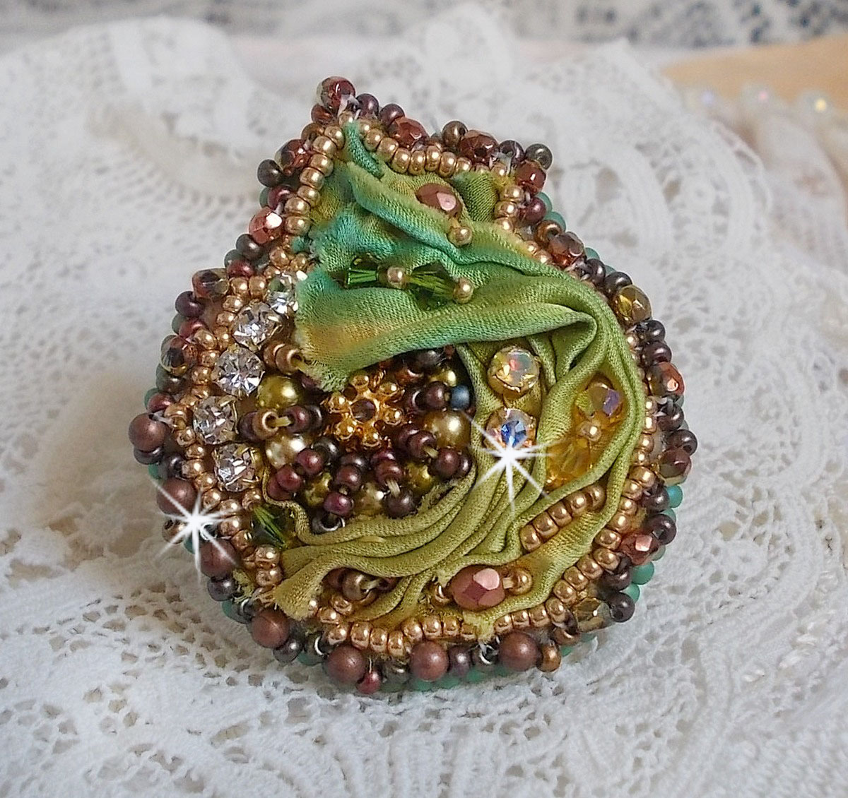 Bague Lune V&eacute;nitienne brod&eacute;e avec un ruban de soie Orange, Vert et Jaune, cristaux : toupies, perles rondes nacr&eacute;es et chatons. S&rsquo;ajoute des facettes et rocailles en Verre sur une bague filigran&eacute;e 
