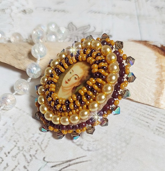 Bague Madame de Pompadour brod&eacute;e avec un cabochon repr&eacute;sentant une femme &agrave; laquelle s'ajoute des toupies, perles rondes nacr&eacute;es, rocailles aux couleurs Jaune et Marron sur bague Bronze en laiton