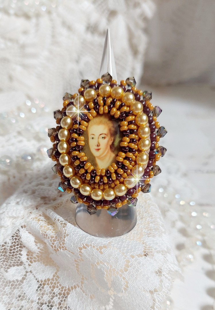 Bague Madame de Pompadour brod&eacute;e avec un cabochon repr&eacute;sentant une femme &agrave; laquelle s'ajoute des toupies, perles rondes nacr&eacute;es, rocailles aux couleurs Jaune et Marron sur bague Bronze en laiton