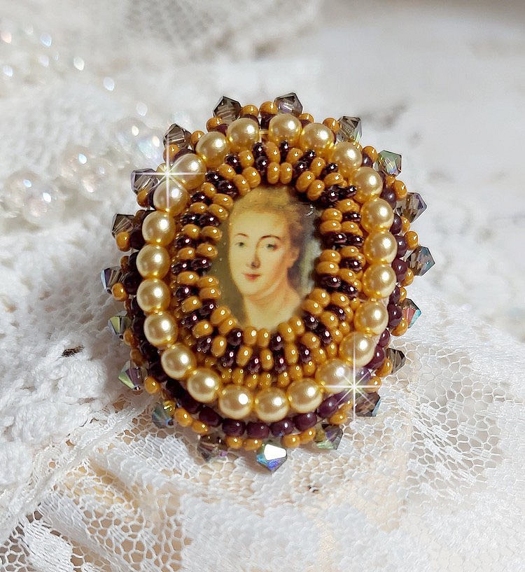 Bague Madame de Pompadour brod&eacute;e avec un cabochon repr&eacute;sentant une femme &agrave; laquelle s'ajoute des toupies, perles rondes nacr&eacute;es, rocailles aux couleurs Jaune et Marron sur bague Bronze en laiton
