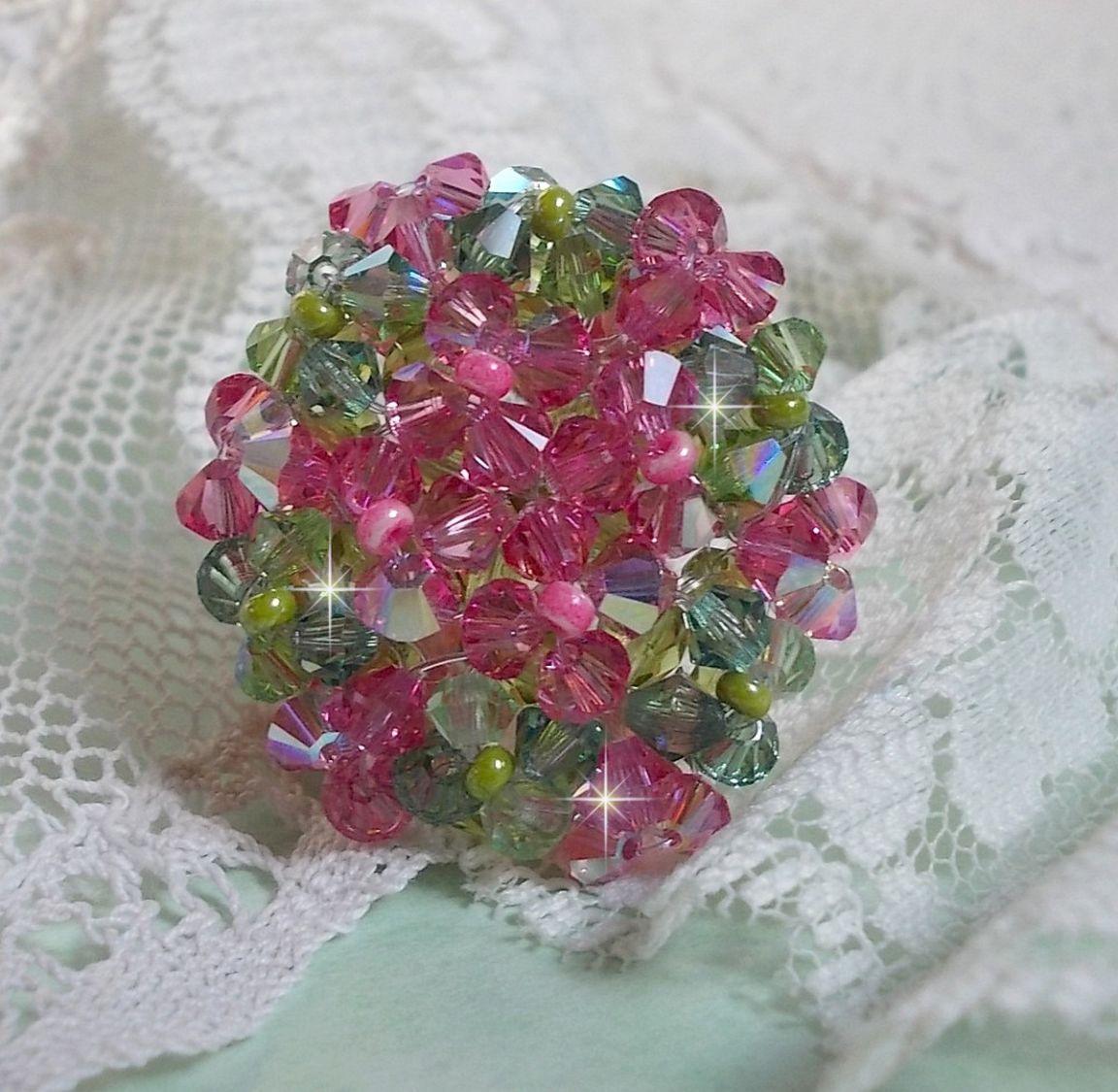 Bague Miss Lady mont&eacute;e avec une superposition de toupies en Cristal de qualit&eacute; AB, facettes de boh&egrave;me de m&ecirc;me qualit&eacute; et rocailles. L&rsquo;ensemble sont de deux couleurs : le Rose et le Vert. El&eacute;gance