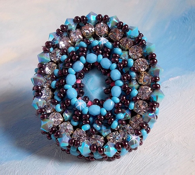Bague Na&iuml;ade brod&eacute;e avec un cabochon facett&eacute; Turquoise, chatons, toupies en Cristal de Swarovski, rocailles sur une bague de couleur Bronze et sur du cuir vachette Camel 