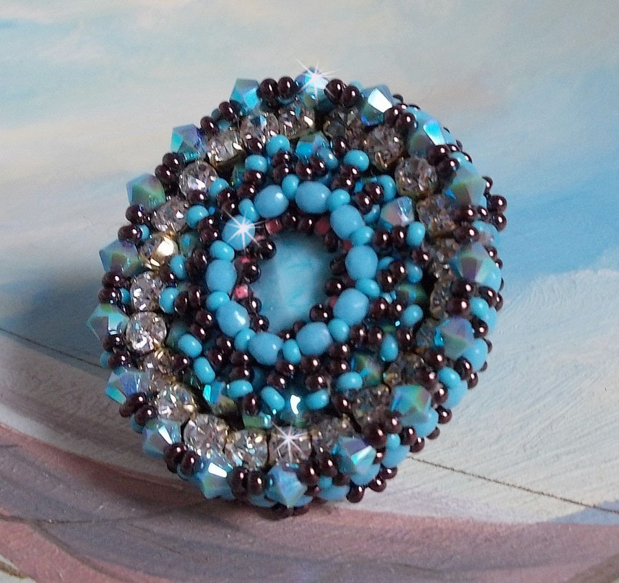 Bague Na&iuml;ade brod&eacute;e avec un cabochon facett&eacute; Turquoise, chatons, toupies en Cristal de Swarovski, rocailles sur une bague de couleur Bronze et sur du cuir vachette Camel 