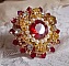 Bague L&rsquo;Oiseau des Iles Rouge Dor&eacute; avec un cabochon Rouge sur une estampe dor&eacute;e orn&eacute;e de cristaux : toupies et chatons. Les perles rondes nacr&eacute;es Ivoire et Rouge compl&egrave;tent cette bague r&eacute;glable Dor&eacute;e