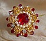 Bague L&rsquo;Oiseau des Iles Rouge Dor&eacute; avec un cabochon Rouge sur une estampe dor&eacute;e orn&eacute;e de cristaux : toupies et chatons. Les perles rondes nacr&eacute;es Ivoire et Rouge compl&egrave;tent cette bague r&eacute;glable Dor&eacute;e