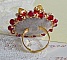 Bague L&rsquo;Oiseau des Iles Rouge Dor&eacute; avec un cabochon Rouge sur une estampe dor&eacute;e orn&eacute;e de cristaux : toupies et chatons. Les perles rondes nacr&eacute;es Ivoire et Rouge compl&egrave;tent cette bague r&eacute;glable Dor&eacute;e