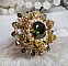 Bague L&rsquo;Oiseau des Iles Vert Dor&eacute;e avec un cabochon Vert sur une estampe dor&eacute;e orn&eacute;e de cristaux : toupies et chatons. Les perles rondes nacr&eacute;es Ivoire et Olivine compl&egrave;te cette bague r&eacute;glable. 