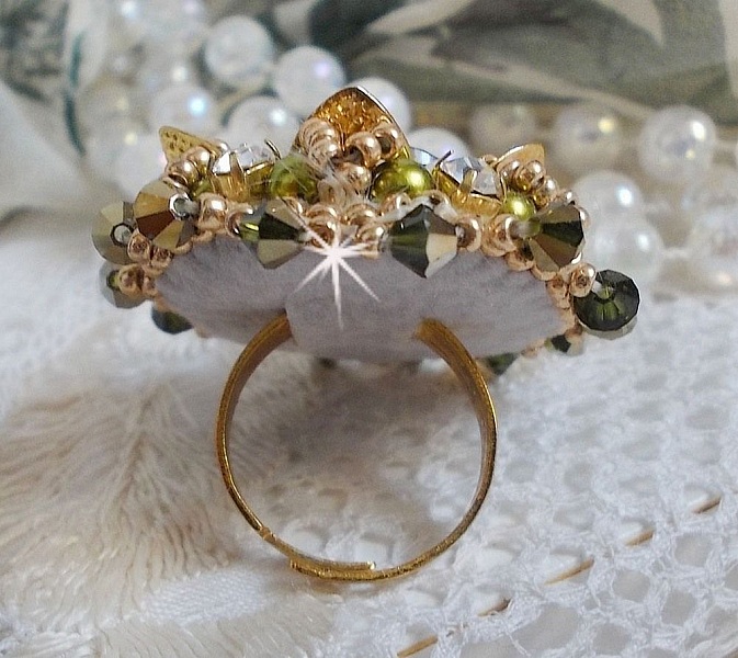 Bague L&rsquo;Oiseau des Iles Vert Dor&eacute;e avec un cabochon Vert sur une estampe dor&eacute;e orn&eacute;e de cristaux : toupies et chatons. Les perles rondes nacr&eacute;es Ivoire et Olivine compl&egrave;te cette bague r&eacute;glable. 