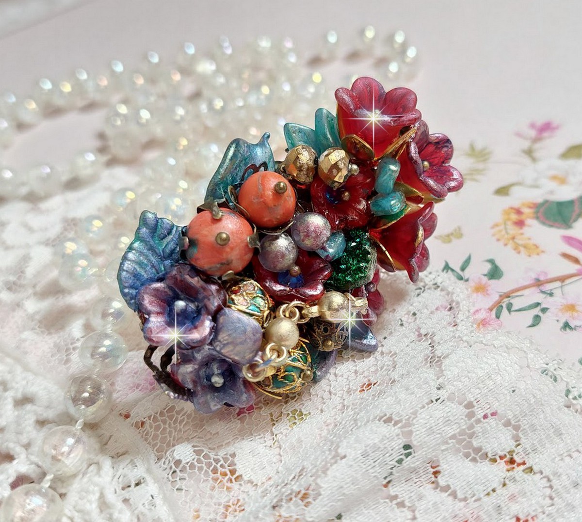Bague Onia pour une composition florale cr&eacute;&eacute;e avec des cristaux, fleurs : perles, clochettes, pens&eacute;es, gouttes Druzy,  pierre de gemme : le Corail, perles cloisonn&eacute;es et bague ovale en Laiton