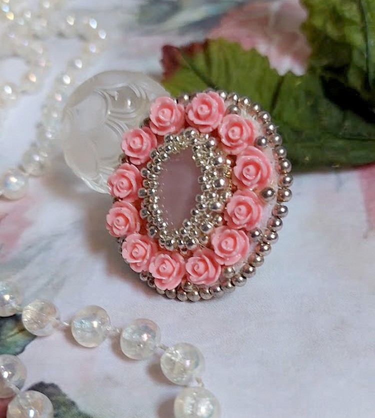 Bague Parisian Roses brod&eacute;e avec une pierre de gemme : le Quartz Rose orn&eacute; de cabochons ronds en forme de rose avec des rocailles Argent&eacute;es japonaises en verre, le tout est mont&eacute; sur bague en laiton