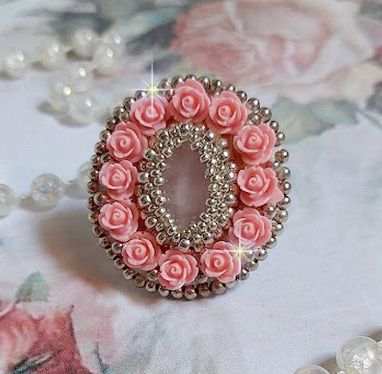 Bague Parisian Roses brod&eacute;e avec une pierre de gemme : le Quartz Rose orn&eacute; de cabochons ronds en forme de rose avec des rocailles Argent&eacute;es japonaises en verre, le tout est mont&eacute; sur bague en laiton