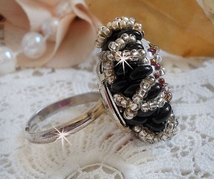 Bague artisanale en perles noires et dorées sur support argenté.