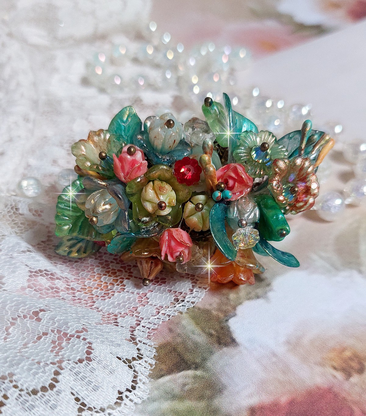Bague Patiflo d&rsquo;une composition florale cr&eacute;&eacute;e avec des cristaux, fleurs en R&eacute;sine, perles, clochettes, pens&eacute;es, boutons de rose en Verre, estampes et coupelles. Le tout est mont&eacute; sur une bague estampe