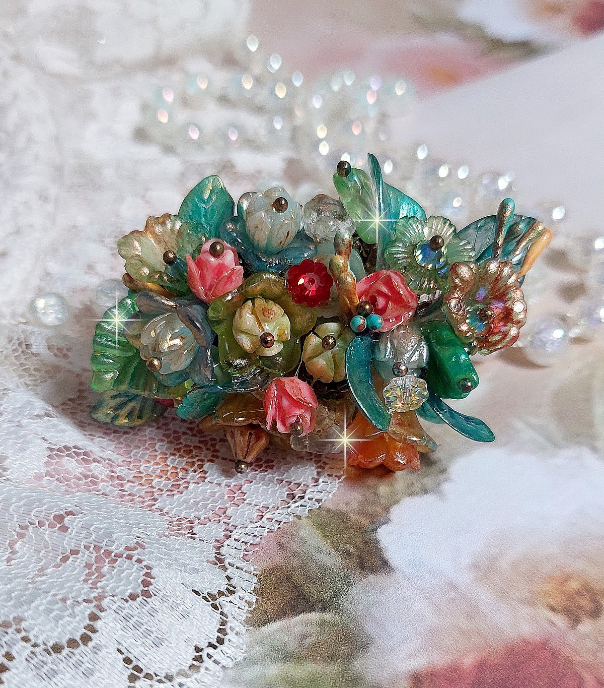 Bague Patiflo d&rsquo;une composition florale cr&eacute;&eacute;e avec des cristaux, fleurs en R&eacute;sine, perles, clochettes, pens&eacute;es, boutons de rose en Verre, estampes et coupelles. Le tout est mont&eacute; sur une bague estampe