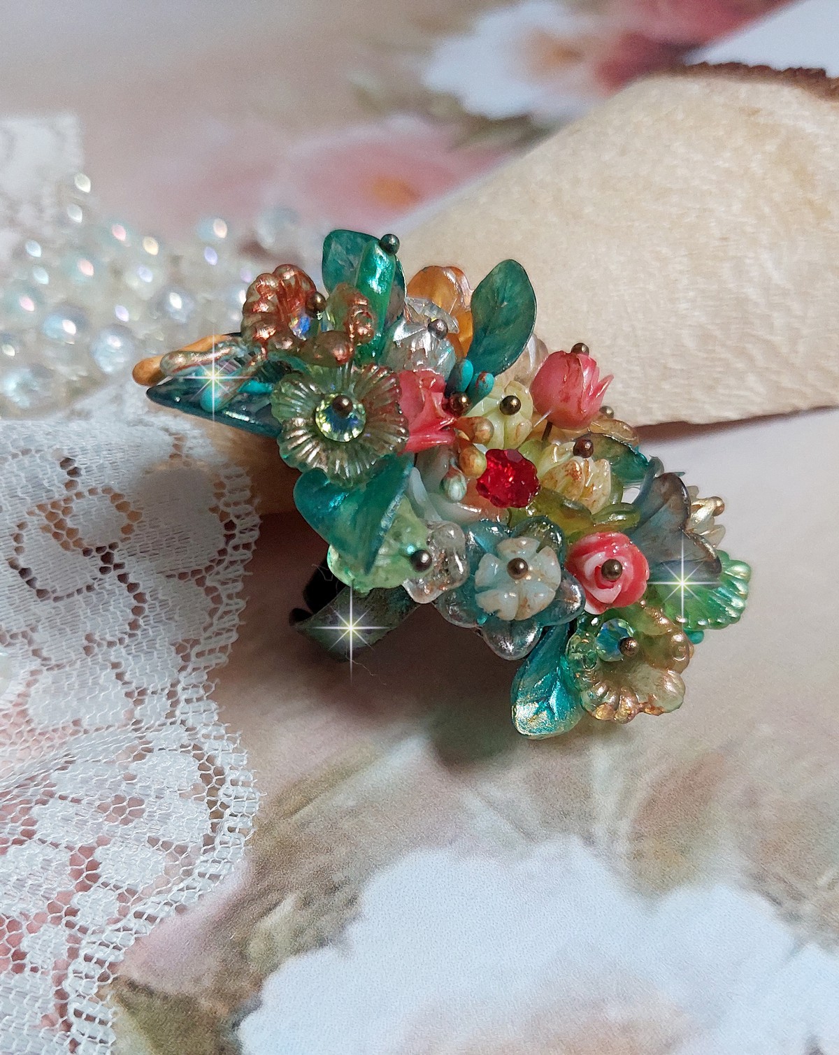 Bague Patiflo d&rsquo;une composition florale cr&eacute;&eacute;e avec des cristaux, fleurs en R&eacute;sine, perles, clochettes, pens&eacute;es, boutons de rose en Verre, estampes et coupelles. Le tout est mont&eacute; sur une bague estampe