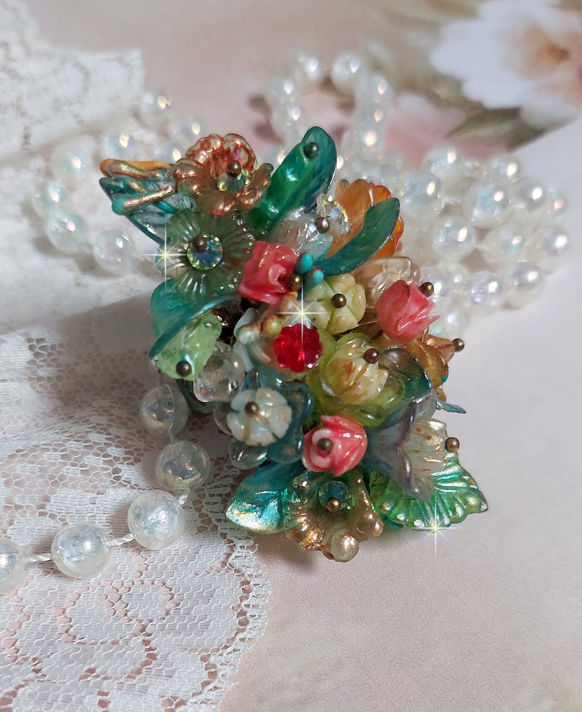 Bague Patiflo d&rsquo;une composition florale cr&eacute;&eacute;e avec des cristaux, fleurs en R&eacute;sine, perles, clochettes, pens&eacute;es, boutons de rose en Verre, estampes et coupelles. Le tout est mont&eacute; sur une bague estampe