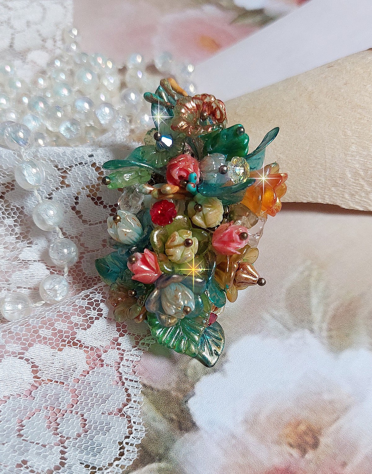 Bague Patiflo d&rsquo;une composition florale cr&eacute;&eacute;e avec des cristaux, fleurs en R&eacute;sine, perles, clochettes, pens&eacute;es, boutons de rose en Verre, estampes et coupelles. Le tout est mont&eacute; sur une bague estampe