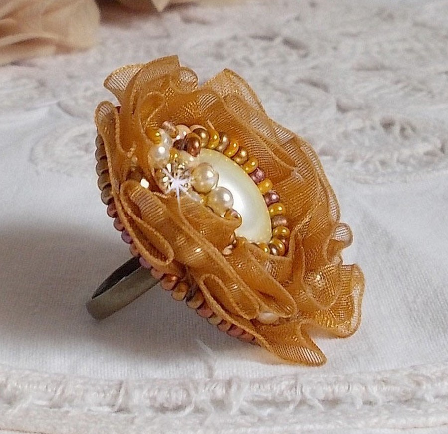 Bague Reflets de Ros&eacute;e brod&eacute;e avec un cam&eacute; ovale Ivoire &agrave; laquelle s'ajoute facettes, perles rondes nacr&eacute;es et rocailles aux couleurs Marron, Ivoire, Caramel sur une bague en laiton Bronze         