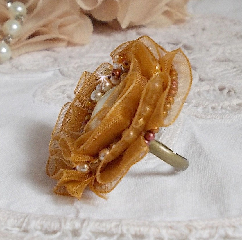 Bague Reflets de Ros&eacute;e brod&eacute;e avec un cam&eacute; ovale Ivoire &agrave; laquelle s'ajoute facettes, perles rondes nacr&eacute;es et rocailles aux couleurs Marron, Ivoire, Caramel sur une bague en laiton Bronze         