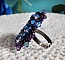 Bague baroque brodée de perles bleues et violettes.