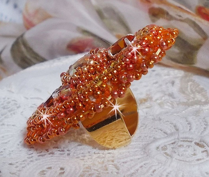 Bague Rumba brod&eacute;e avec un cabochon en Cristal de Swarovski Sunshine orn&eacute;e de facettes Cristal Jaune/Orange et Abricot &agrave; laquelle s'ajoute des chatons, rocailles Oranges et Dor&eacute;es sur bague Dor&eacute;e