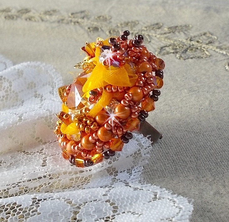 Bague Les R&ecirc;ves d'Acapulco brod&eacute;e avec un cabochon octogonale serti &agrave; laquelle s'ajoute perles rondes nacr&eacute;es, ruban organza, toupies et rocailles sur bague en laiton Bronze pour un style ethnique