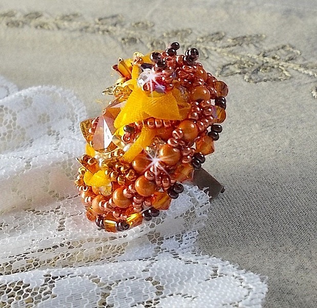 Bague Les R&ecirc;ves d'Acapulco brod&eacute;e avec un cabochon octogonale serti &agrave; laquelle s'ajoute perles rondes nacr&eacute;es, ruban organza, toupies et rocailles sur bague en laiton Bronze pour un style ethnique