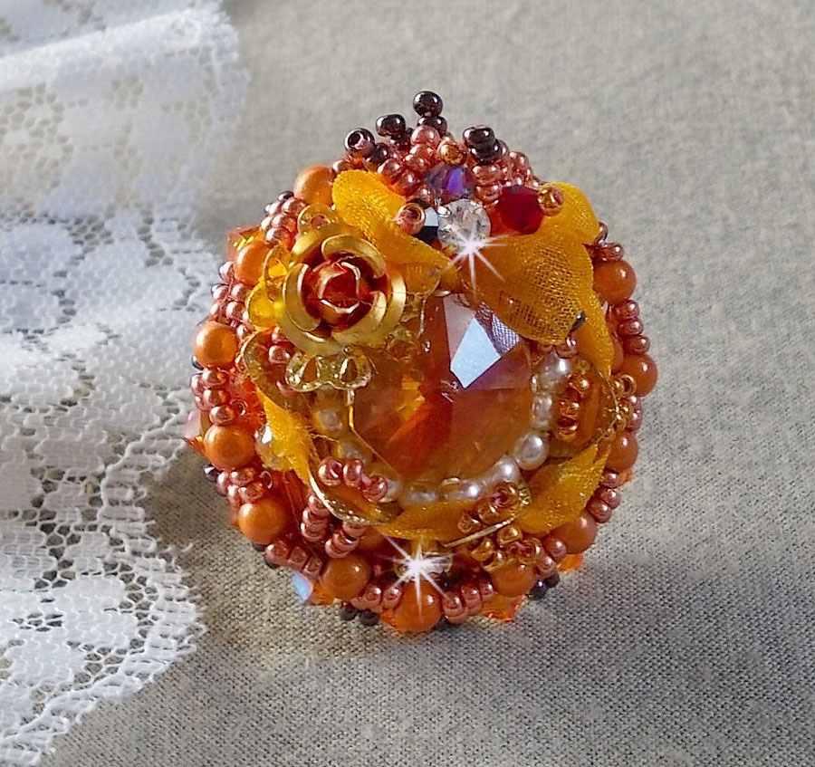 Bague Les R&ecirc;ves d'Acapulco brod&eacute;e avec un cabochon octogonale serti &agrave; laquelle s'ajoute perles rondes nacr&eacute;es, ruban organza, toupies et rocailles sur bague en laiton Bronze pour un style ethnique