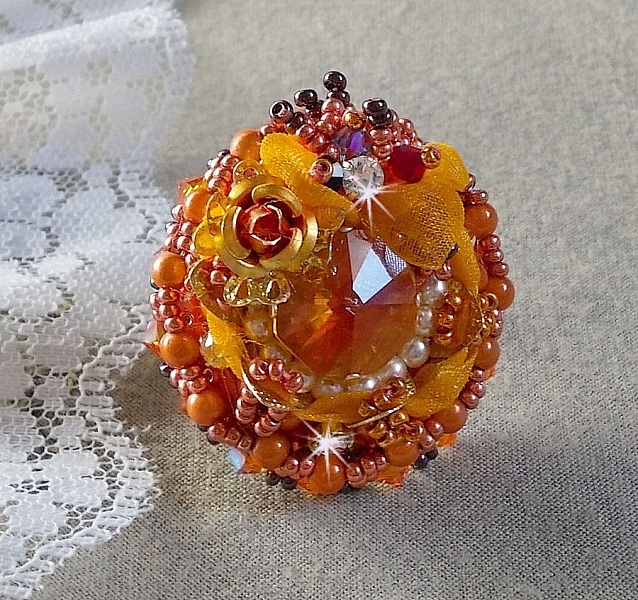 Bague Les R&ecirc;ves d'Acapulco brod&eacute;e avec un cabochon octogonale serti &agrave; laquelle s'ajoute perles rondes nacr&eacute;es, ruban organza, toupies et rocailles sur bague en laiton Bronze pour un style ethnique