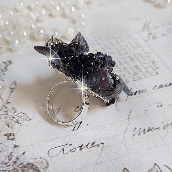Bague Soir de Lune cr&eacute;&eacute;e avec des fleurs lucites Noires et Grises peintes &agrave; la main, cristaux, perles en r&eacute;sine, perles en verre et coupelle argent&eacute;e. Le tout est mont&eacute; sur une bague argent&eacute;e