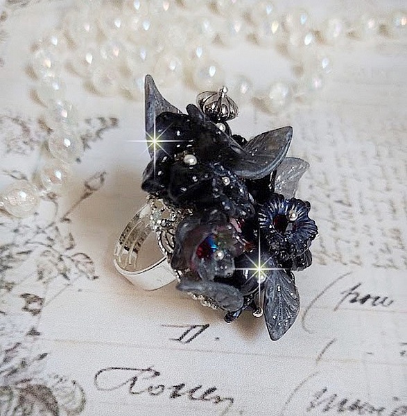 Bague Soir de Lune cr&eacute;&eacute;e avec des fleurs lucites Noires et Grises peintes &agrave; la main, cristaux, perles en r&eacute;sine, perles en verre et coupelle argent&eacute;e. Le tout est mont&eacute; sur une bague argent&eacute;e