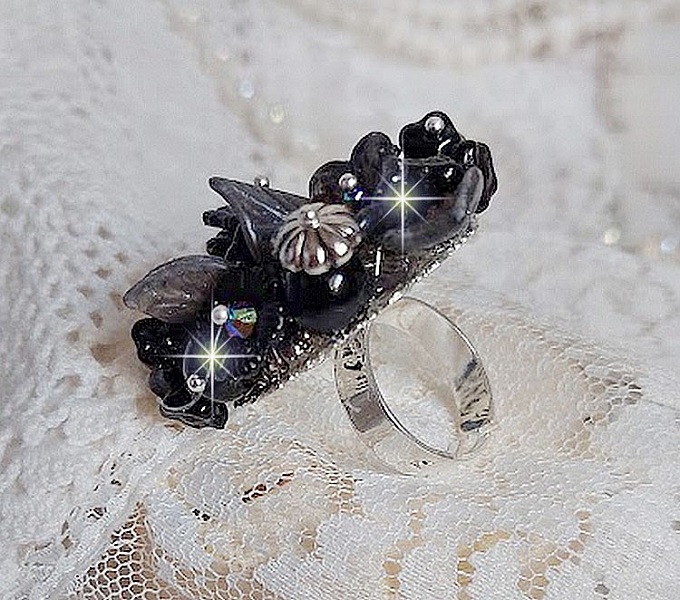 Bague Soir de Lune cr&eacute;&eacute;e avec des fleurs lucites Noires et Grises peintes &agrave; la main, cristaux, perles en r&eacute;sine, perles en verre et coupelle argent&eacute;e. Le tout est mont&eacute; sur une bague argent&eacute;e