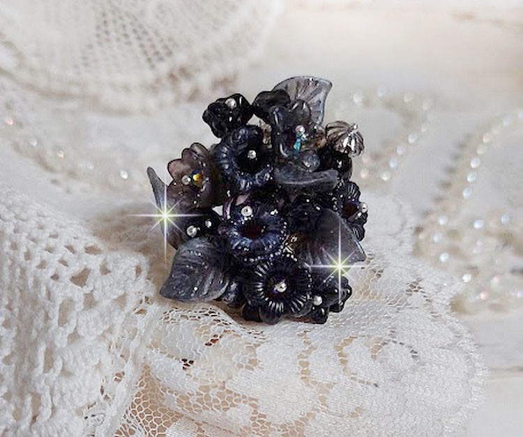 Bague Soir de Lune cr&eacute;&eacute;e avec des fleurs lucites Noires et Grises peintes &agrave; la main, cristaux, perles en r&eacute;sine, perles en verre et coupelle argent&eacute;e. Le tout est mont&eacute; sur une bague argent&eacute;e