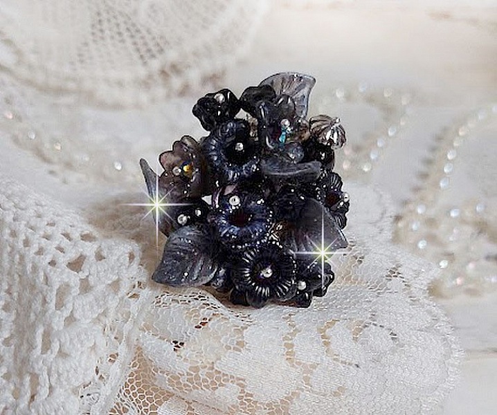 Bague Soir de Lune cr&eacute;&eacute;e avec des fleurs lucites Noires et Grises peintes &agrave; la main, cristaux, perles en r&eacute;sine, perles en verre et coupelle argent&eacute;e. Le tout est mont&eacute; sur une bague argent&eacute;e