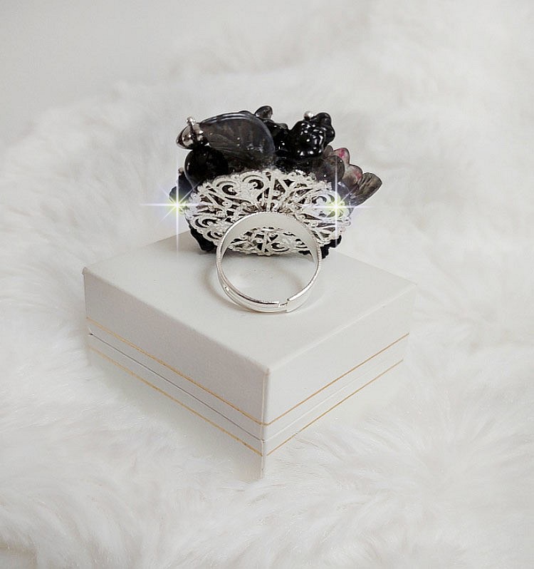 Bague Soir de Lune cr&eacute;&eacute;e avec des fleurs lucites Noires et Grises peintes &agrave; la main, cristaux, perles en r&eacute;sine, perles en verre et coupelle argent&eacute;e. Le tout est mont&eacute; sur une bague argent&eacute;e