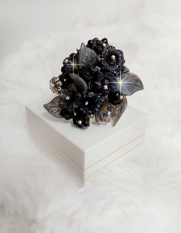 Bague Soir de Lune cr&eacute;&eacute;e avec des fleurs lucites Noires et Grises peintes &agrave; la main, cristaux, perles en r&eacute;sine, perles en verre et coupelle argent&eacute;e. Le tout est mont&eacute; sur une bague argent&eacute;e