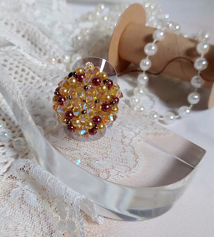 Bague Soleil mont&eacute;e avec des toupies en Cristal de Swarovski aux couleurs Topaze, Gold et Marron &agrave; laquelle s&rsquo;ajoute des facettes en Verre de Boh&egrave;me. Les perles s&rsquo;entrelacent avec les rocailles Dor&eacute;es