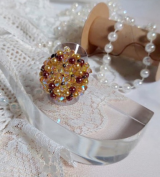 Bague Soleil mont&eacute;e avec des toupies en Cristal de Swarovski aux couleurs Topaze, Gold et Marron &agrave; laquelle s&rsquo;ajoute des facettes en Verre de Boh&egrave;me. Les perles s&rsquo;entrelacent avec les rocailles Dor&eacute;es