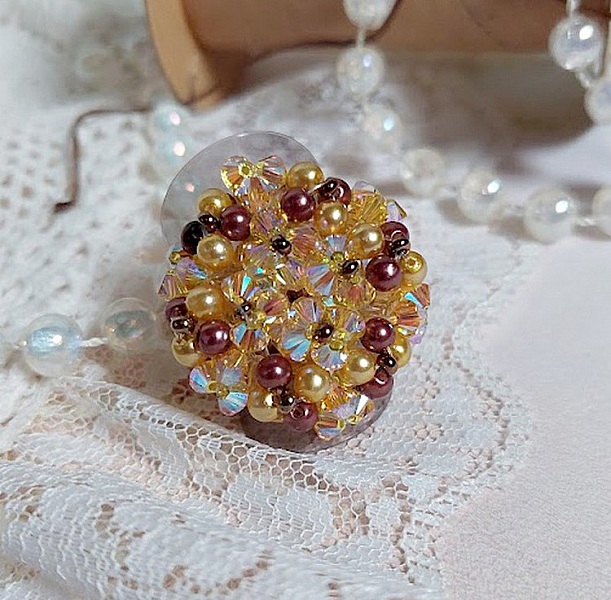 Bague Soleil mont&eacute;e avec des toupies en Cristal de Swarovski aux couleurs Topaze, Gold et Marron &agrave; laquelle s&rsquo;ajoute des facettes en Verre de Boh&egrave;me. Les perles s&rsquo;entrelacent avec les rocailles Dor&eacute;es