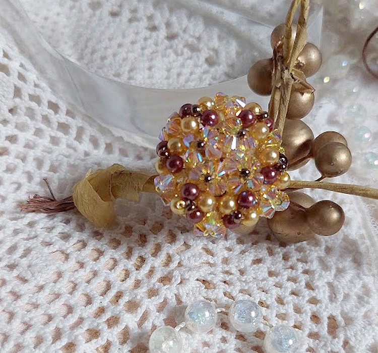 Bague Soleil mont&eacute;e avec des toupies en Cristal de Swarovski aux couleurs Topaze, Gold et Marron &agrave; laquelle s&rsquo;ajoute des facettes en Verre de Boh&egrave;me. Les perles s&rsquo;entrelacent avec les rocailles Dor&eacute;es