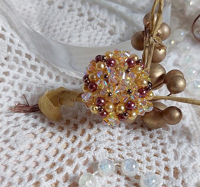 Bague Soleil mont&eacute;e avec des toupies en Cristal de Swarovski aux couleurs Topaze, Gold et Marron &agrave; laquelle s&rsquo;ajoute des facettes en Verre de Boh&egrave;me. Les perles s&rsquo;entrelacent avec les rocailles Dor&eacute;es