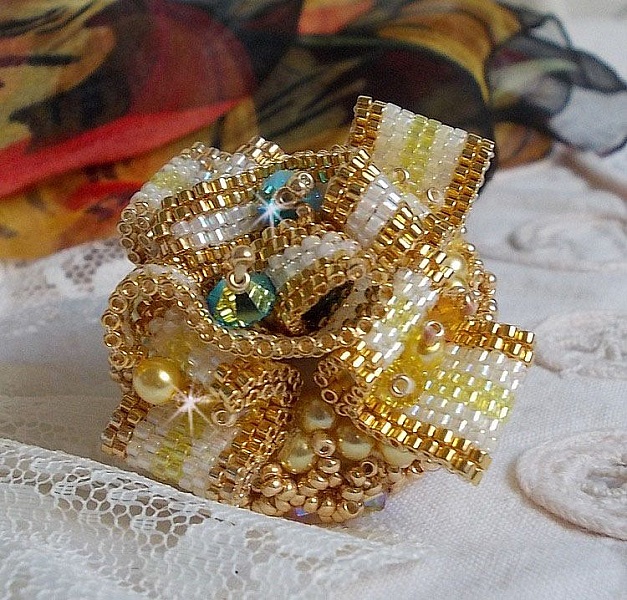 Bague Sunflower Gold brod&eacute;e d&rsquo;un ruban que j&rsquo;ai mis en forme avec des rocailles plaqu&eacute;es or 24 carats, perles nacr&eacute;es en cristal, toupies, perle ronde nacr&eacute;e. Le tout est mont&eacute; sur une bague Dor&eacute;e