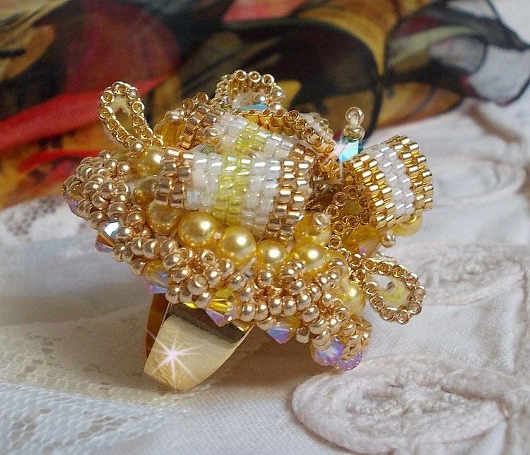 Bague Sunflower Gold brod&eacute;e d&rsquo;un ruban que j&rsquo;ai mis en forme avec des rocailles plaqu&eacute;es or 24 carats, perles nacr&eacute;es en cristal, toupies, perle ronde nacr&eacute;e. Le tout est mont&eacute; sur une bague Dor&eacute;e