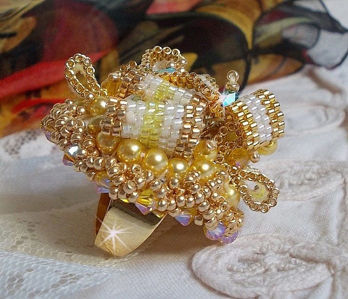 Bague Sunflower Gold brod&eacute;e d&rsquo;un ruban que j&rsquo;ai mis en forme avec des rocailles plaqu&eacute;es or 24 carats, perles nacr&eacute;es en cristal, toupies, perle ronde nacr&eacute;e. Le tout est mont&eacute; sur une bague Dor&eacute;e