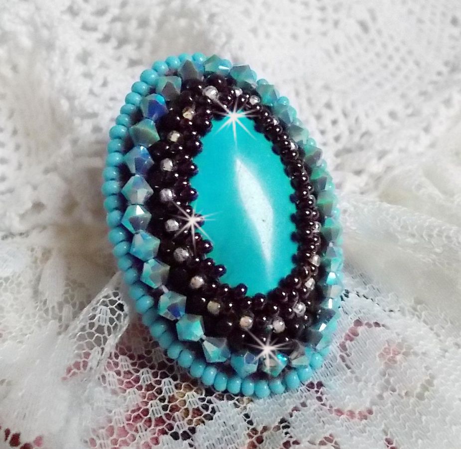 Bague Turquoise au style Am&eacute;rindien avec un cabochon ovale en pierre de gemme : le Turquoise lui-m&ecirc;me orn&eacute; de toupies en Cristal, s&rsquo;ajoute des rocailles en verre Miyuki et tch&egrave;que sur une bague Bronze
