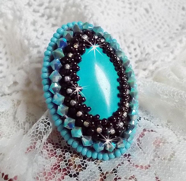 Bague Turquoise au style Am&eacute;rindien avec un cabochon ovale en pierre de gemme : le Turquoise lui-m&ecirc;me orn&eacute; de toupies en Cristal, s&rsquo;ajoute des rocailles en verre Miyuki et tch&egrave;que sur une bague Bronze