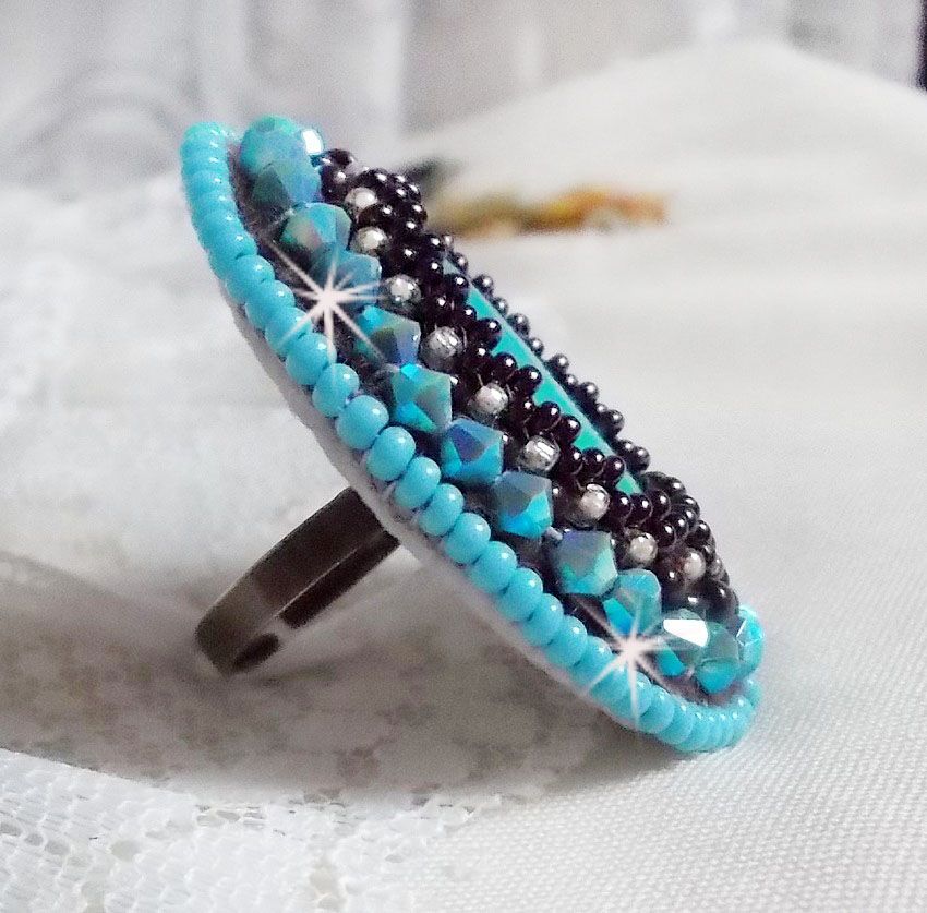 Bague Turquoise au style Am&eacute;rindien avec un cabochon ovale en pierre de gemme : le Turquoise lui-m&ecirc;me orn&eacute; de toupies en Cristal, s&rsquo;ajoute des rocailles en verre Miyuki et tch&egrave;que sur une bague Bronze