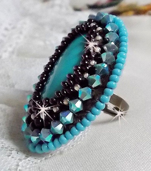 Bague Turquoise au style Am&eacute;rindien avec un cabochon ovale en pierre de gemme : le Turquoise lui-m&ecirc;me orn&eacute; de toupies en Cristal, s&rsquo;ajoute des rocailles en verre Miyuki et tch&egrave;que sur une bague Bronze